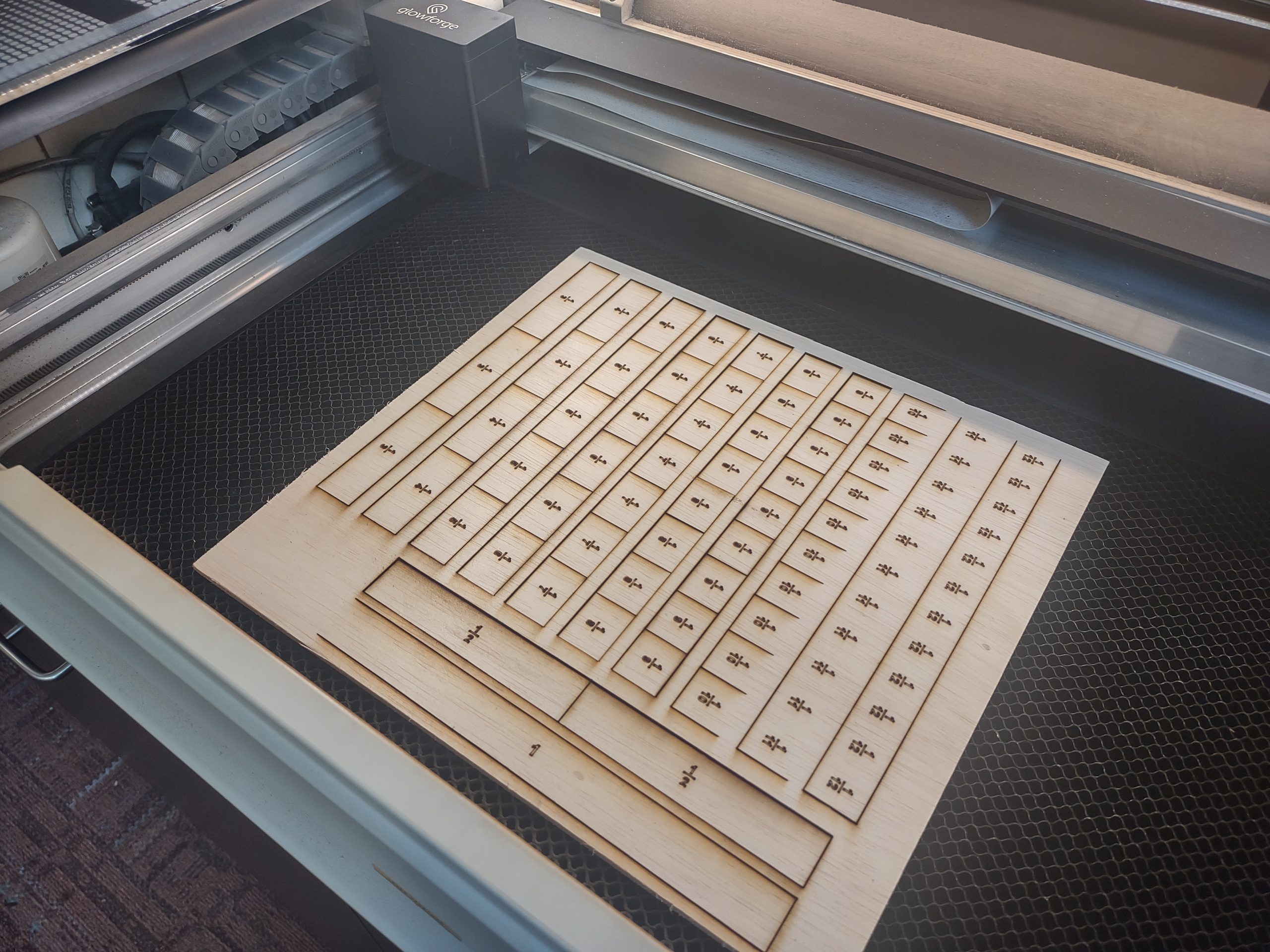 Glowforge laser printer with wooden fraction puzzle
